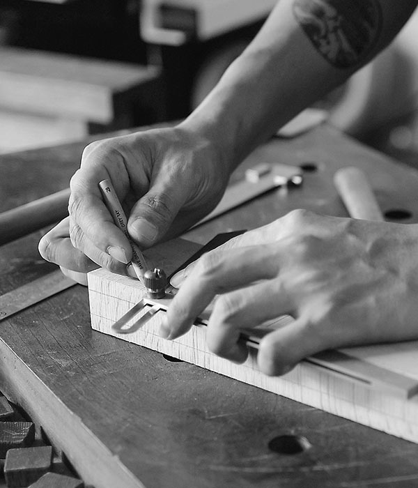 black and white photo of a person measuring wood