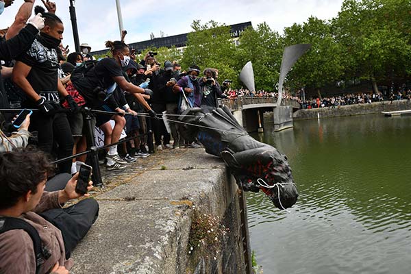 statue being dumped into a river