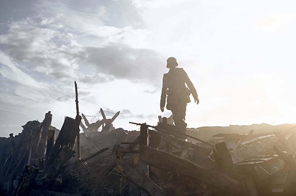 soldier standing above trenches in war movie