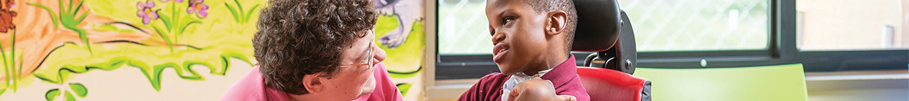 A therapist talking to a child in a Rifton Activity Chair