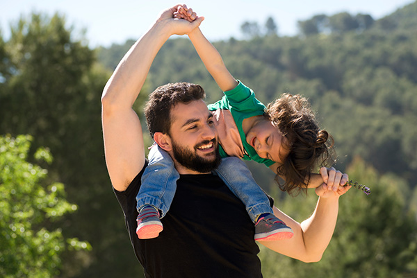 a girl sitting on her father's shoulders