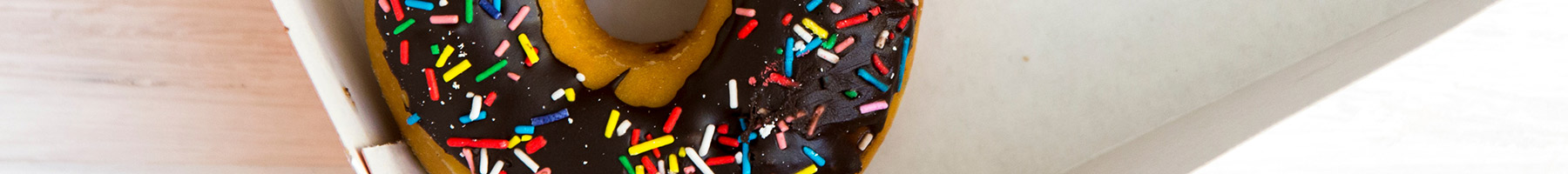 a chocolate and sprinkle covered donut in a box