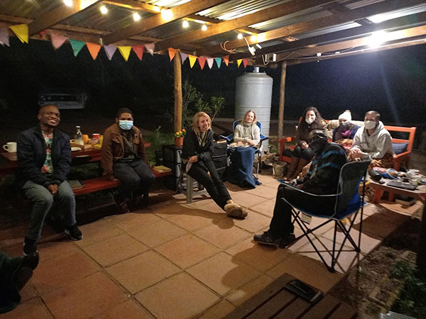 people sitting outside a tiny house