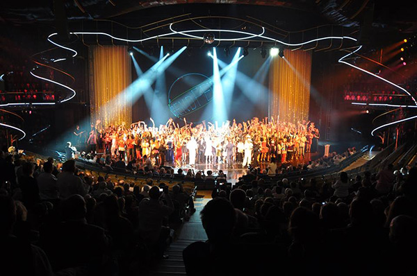 a crowd of young people on a lighted stage