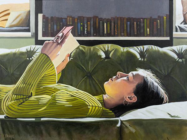 a woman reading a book on a green sofa