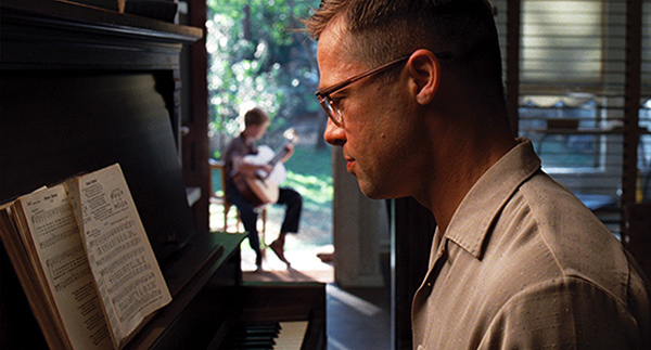 a man playing piano and a boy playing guitar