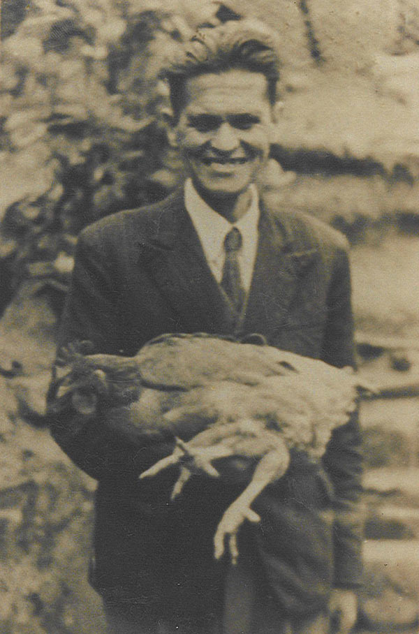 Photograph of man in suit holding chicken