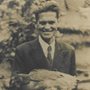 Photograph of man in suit holding chicken