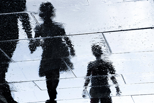 shadows of a parent and children on a rainy day