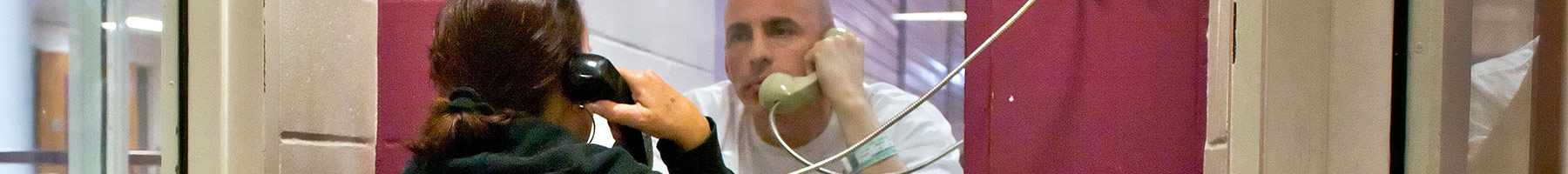 Prisoner talks with his wife on a telephone in a jail