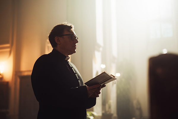 a priest holding a book