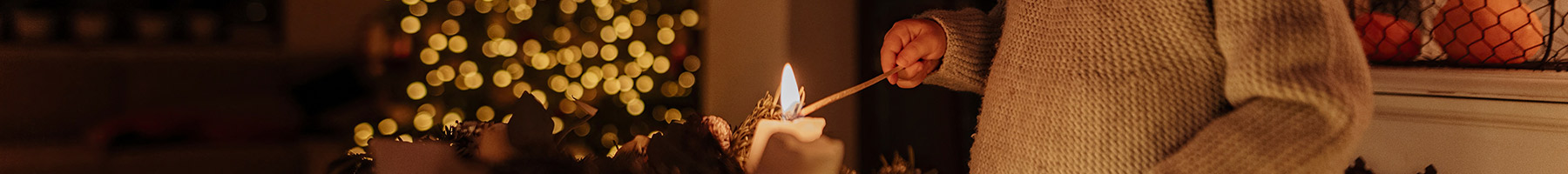 a little girl lighting an Advent candle