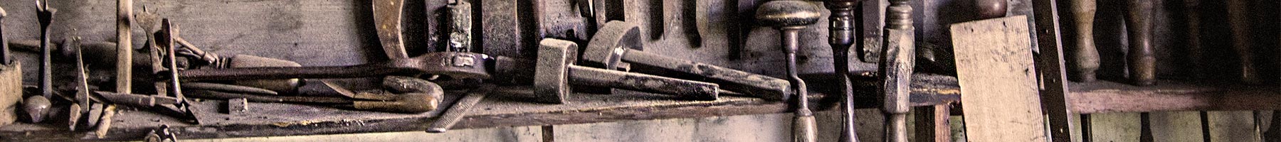 a collection of chisels and hammers at a work bench