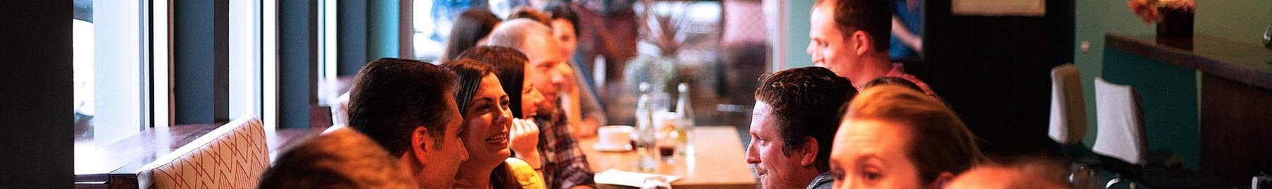 people conversing with each other across a cafe table