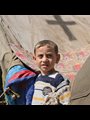 a refugee child with a tent in the background