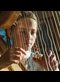 Marlys plays the harp her father made
