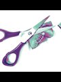 a pair of scissors next to cut up photographs of a baby