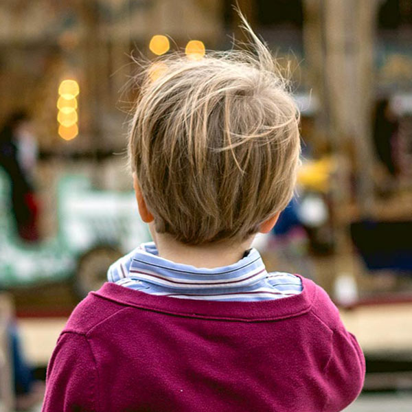 boy looking at lights on a carousel