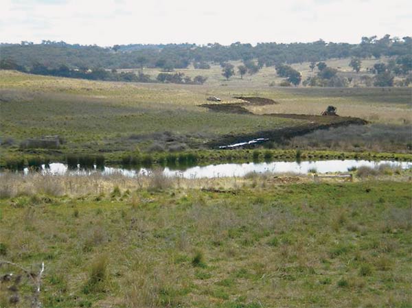 a bulldozer moving earth near a stream