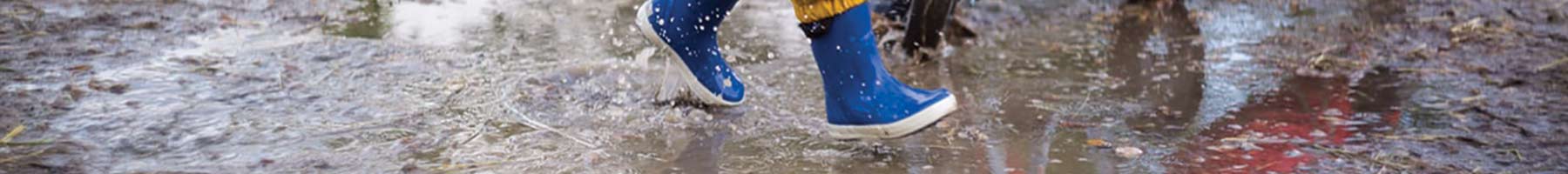 childrens feet splashing in puddle