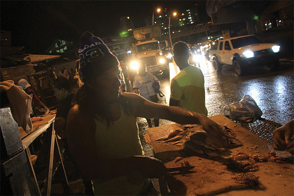 people at night lit up by car headlights