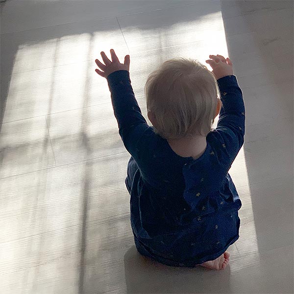 photo of a baby dancing in sunlight