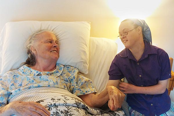 a young woman with Down syndrome sitting beside her elderly mother