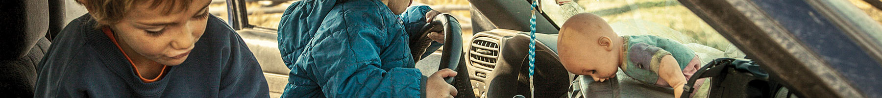 two kids playing in an old car