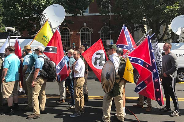 Alt-right members preparing to enter Emancipation Park holding Nazi, Confederate, and Gadsden Don't Tread on Me flags.