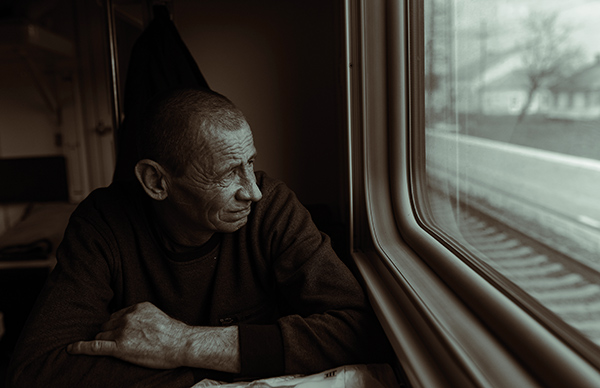 an elderly man looking out of a window