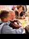 an elderly man sits with a young visitor to a community center