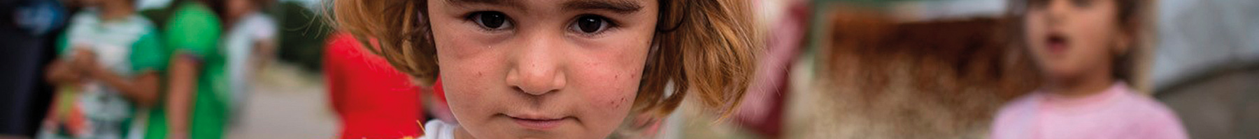 portrait of a refugee girl in a white and yellow dress