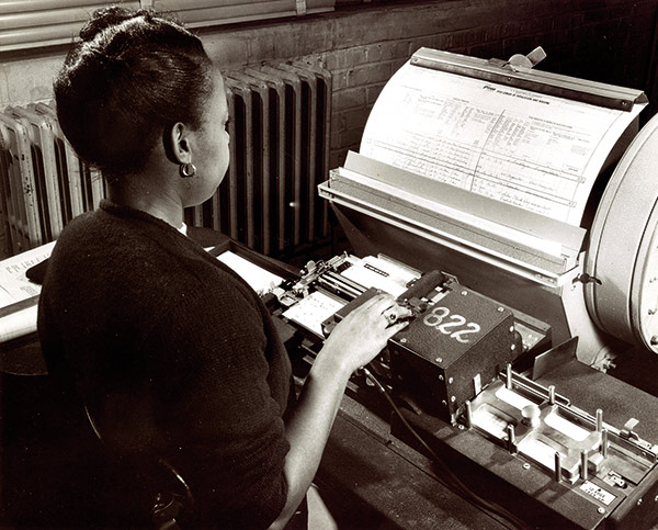 a clerk creating punched cards containing data