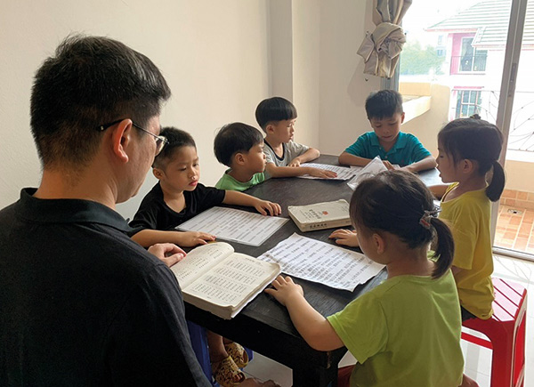 children reading around a table