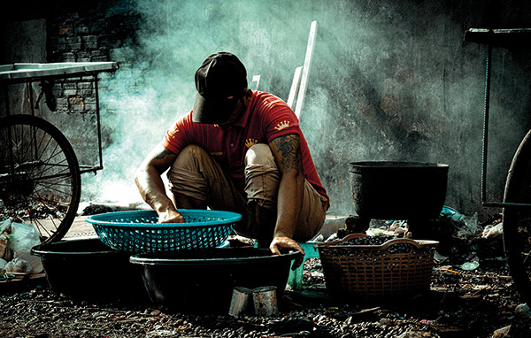 poor man working with some shallow dishes