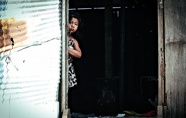 child at the door of a corrugated iron house