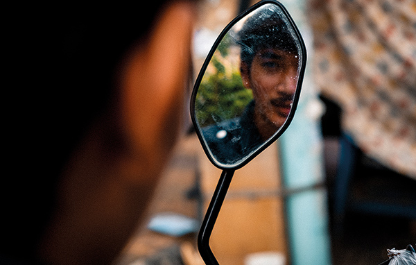 man's face in a motorbike mirror