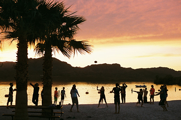 Teenagers on a beach at sunset