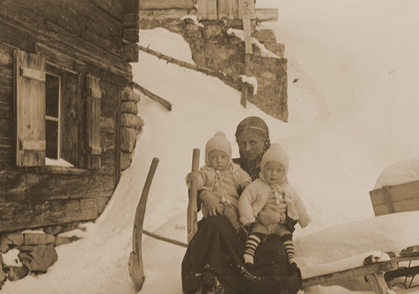 Bruderhof mother holding two children