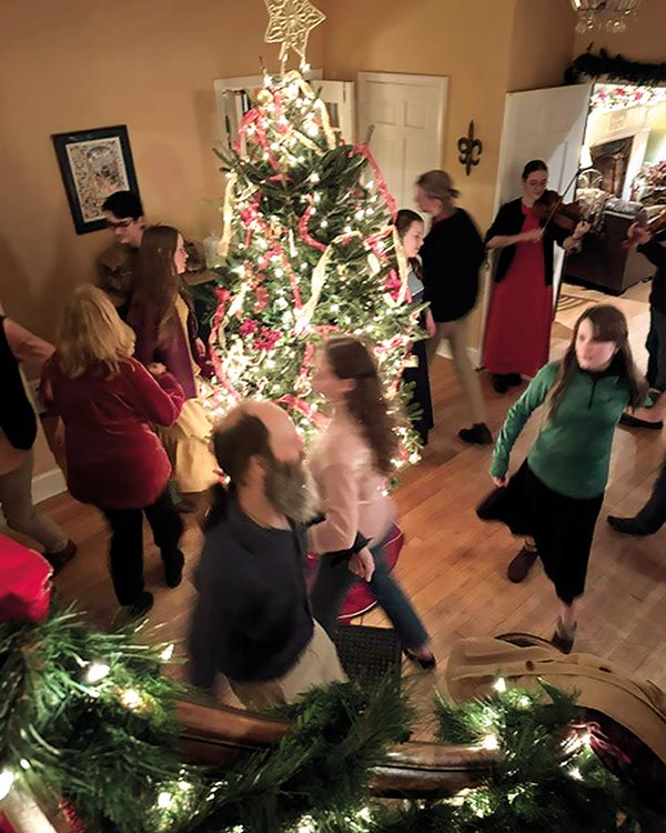 family around a lit christmas tree