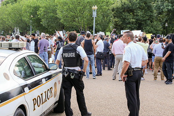 police man with his car by a crowd